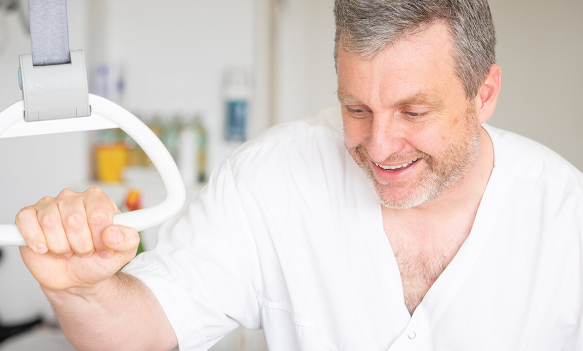 Pflegefachkraft lächelt älterer Patientin zu