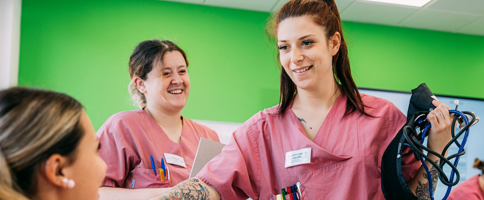 Mehrere Pflegeschülerinnen und Schüler messen einander Blutdruck in der Berufsschule für Pflegefachhilfe Buchloe | © Kliniken Ostallgäu-Kaufbeuren