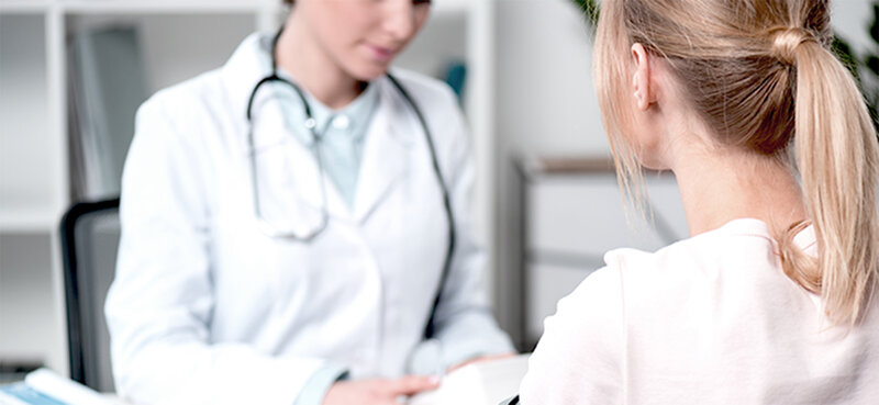 Ärztin bespricht Therapie mit Patientin anhand digitaler Endgeräte