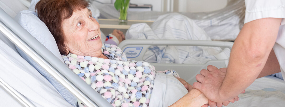 ältere Patientin im Gespräch mit einer Pflegekraft