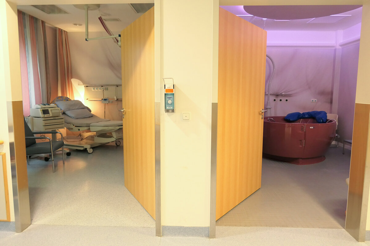 Einblick in zwei freundlich gestaltete Kreißsäle, einer davon mit einer Badewanne mit der Option für eine Wassergeburt
