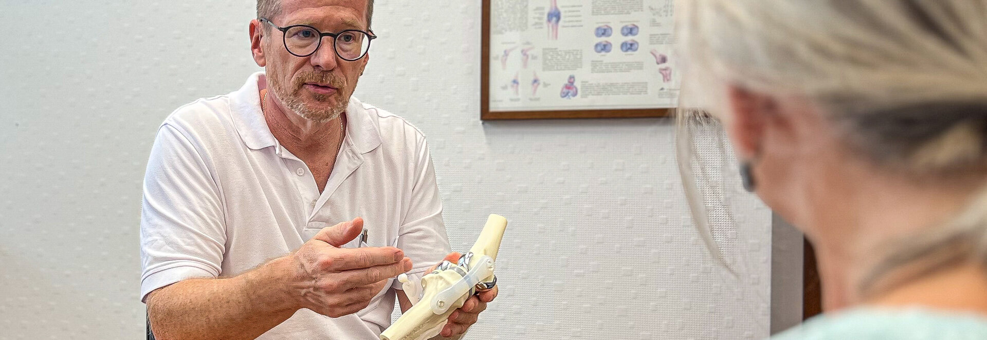 Orthopädie-Chefarzt Dr. Steffen Vennemann erklärt einer Patientin den Aufbau eines Kniegelenks | © Kliniken Ostallgäu-Kaufbeuren