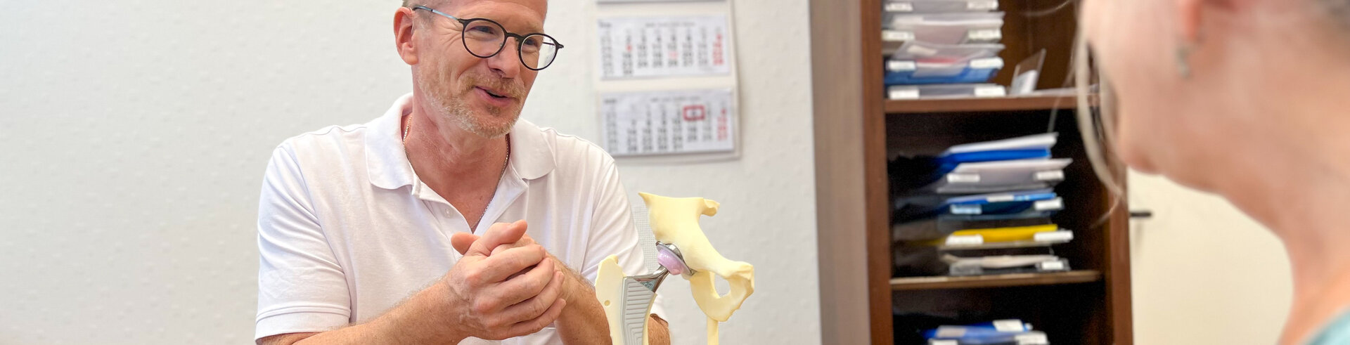 Orthopädie-Chefarzt Dr. Steffen Vennemann erklärt einer Patientin den Aufbau eines Hüftgelenks | © Kliniken Ostallgäu-Kaufbeuren