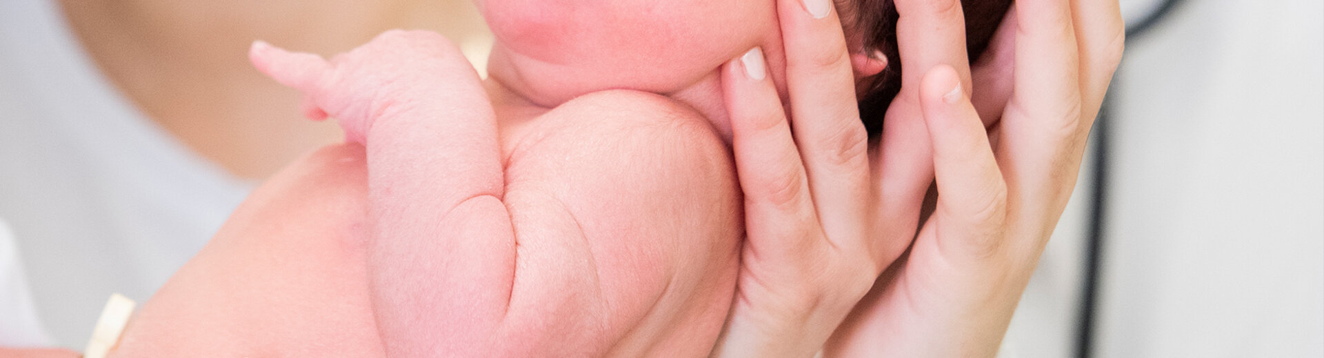 Neugeborenes Baby wird im Arm gehalten