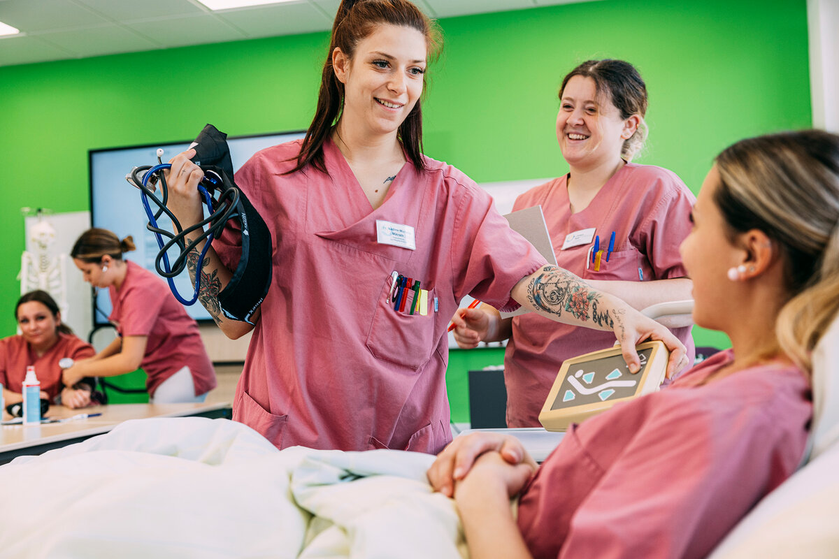 Pflegeschüler beim Üben des Blutdruckmessens – praktische Ausbildung