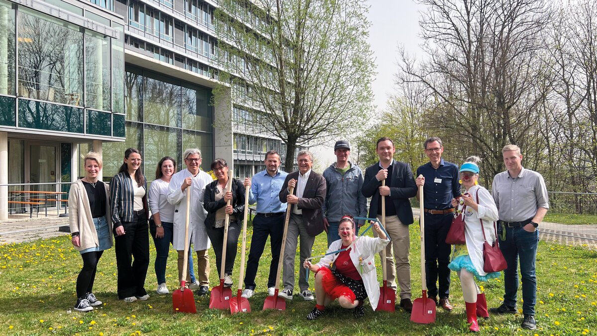 Vertreter*Innen der Kinderkrebshilfe Königswinkel und der Kliniken Ostallgäu-Kaufbeuren feiern den Spatenstich für den Therapie-Spielplatz gemeinsam: Kathrin Damnig, Kathrin Hipp, Kerstin Uhlig Prof. Markus Rauchenzauner, Andrea Lehmann, Axel Wagner, Dr. Rainer Karg, Hermann Härtl, Klinikclown Margit Obermaier, Andreas Kutschker, Josef Streitel, Klinikclown Christiane Ziegler, Markus Wiggenhauser | © Kliniken Ostallgäu-Kaufbeuren