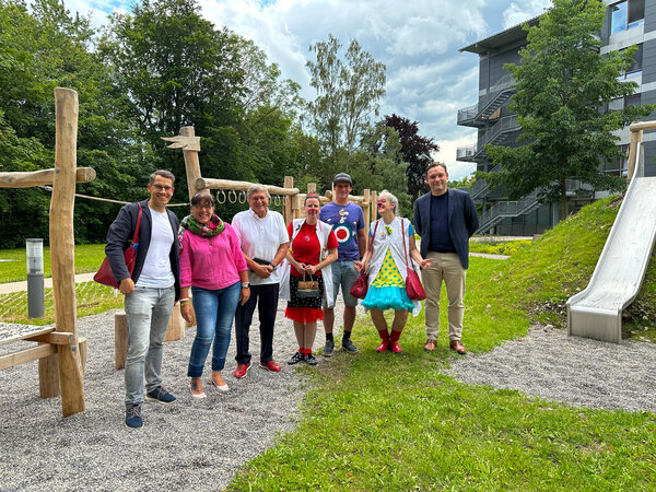 Vertreter:innen der Kinderkrebshilfe Königswinkel und der Kliniken Ostallgäu-Kaufbeuren feiern die Eröffnung des Therapie-Spielplatzes gemeinsam: Oliver Wunder, Andrea Lehmann, Dr. Rainer Karg, Klinikclown Christiane Ziegler, Hermann Härtl, Klinikclown Margit Obermaier, Andreas Kutschker