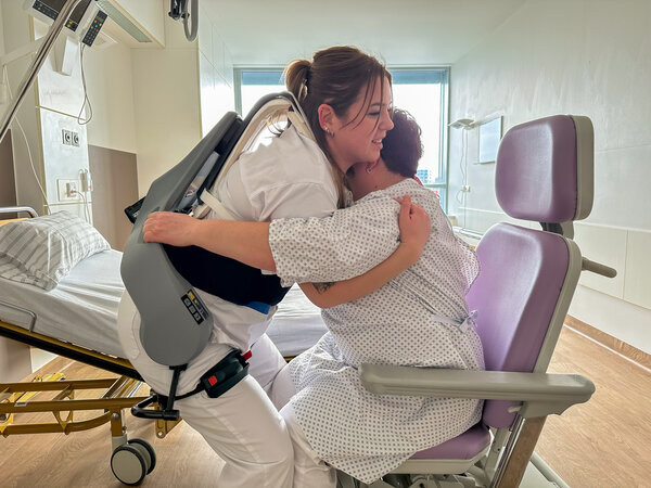 Pflegekraft Gamze Gürtürk beim Umlagern einer Patientin mithilfe des neuen Ausßenskeletts.  | © Foto: Kliniken Ostallgäu-Kaufbeuren